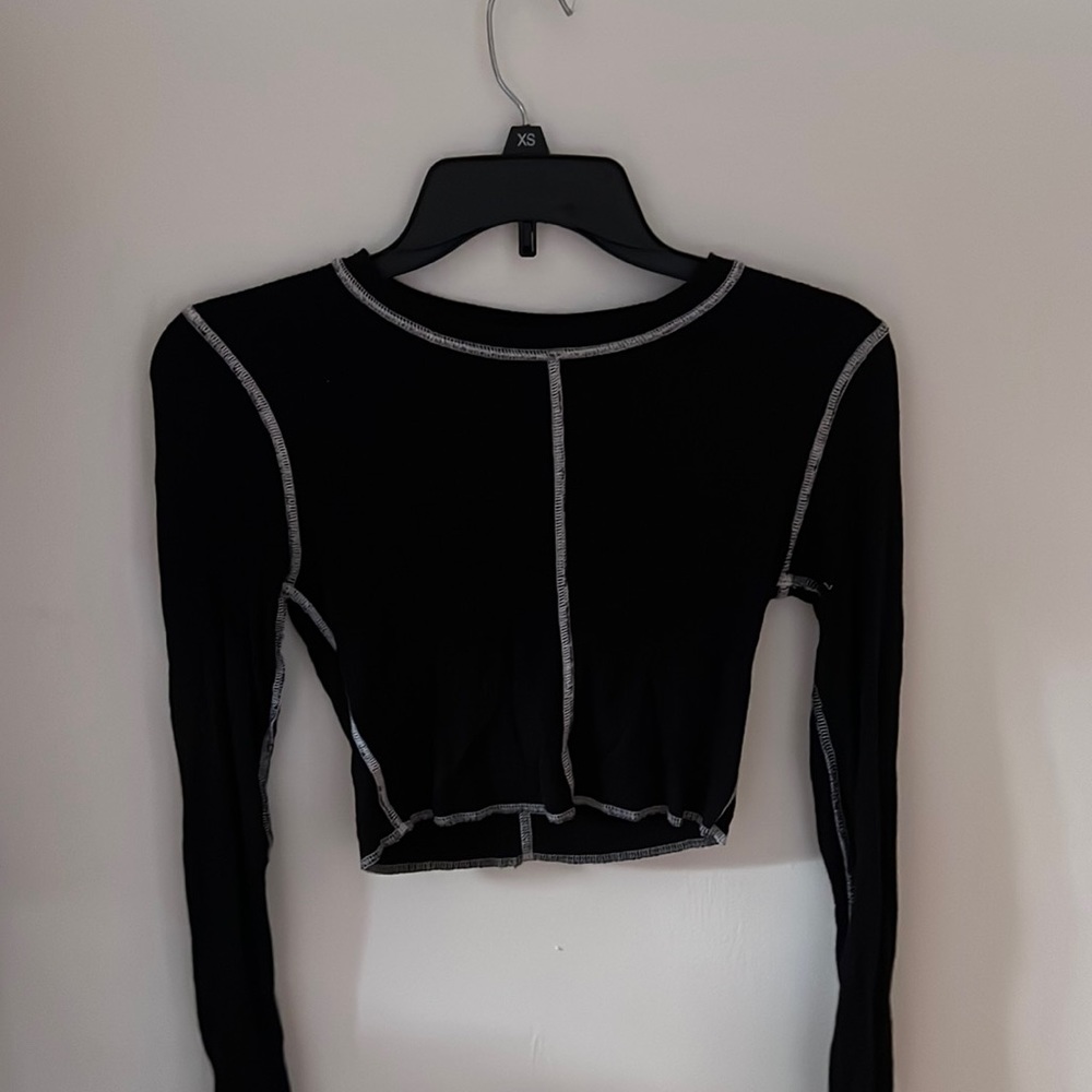 A cropped black with outside stitching top. Super trendy and cute. Size small.